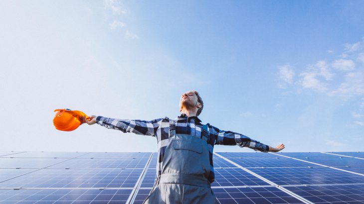 Man worker in the firld by the solar panels