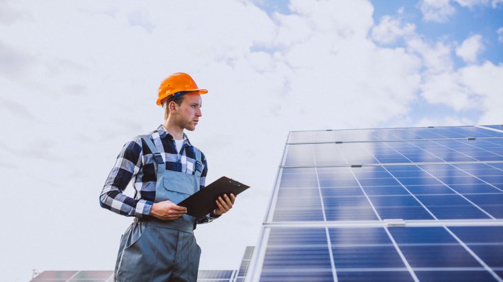 Man worker in the firld by the solar panels